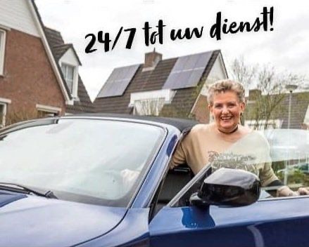 Riet Quaden bij haar auto, met de tekst 24/7 tot uw dienst